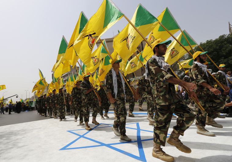 Iraqi Shi'ite Muslim men from the Iranian-backed group Kataib Hezbollah wave the party's flags as they walk along a street painted in the colours of the Israeli flag during a parade marking the annual Quds Day (Reuters)