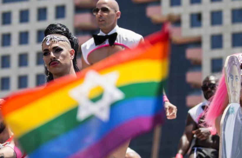 Israeli drag queens and go-go dancers dance on a truck during the annual gay pride parade in the Israeli coastal city of Tel Aviv on June 13, 2014.  (photo credit: JACK GUEZ / AFP)