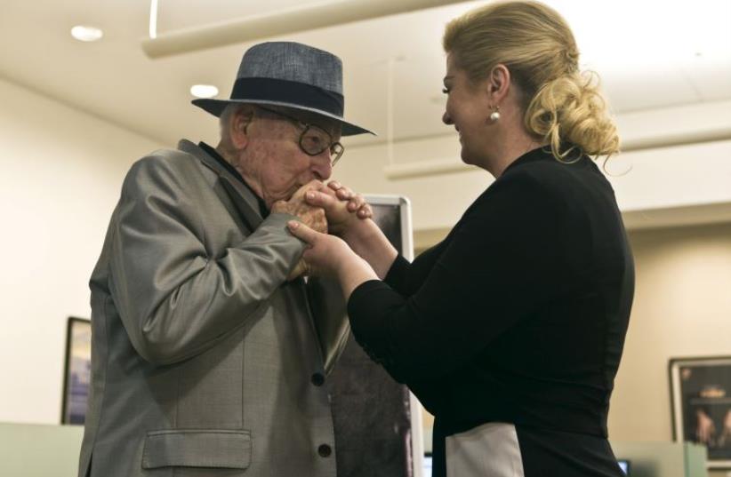 Croatian Auschwitz survivor Branko Lustig (L) kisses the hand of Croatian President Kolinda Grabar-Kitarovic at Yad Vashem Holocaust memorial in Jerusalem (photo credit: REUTERS)