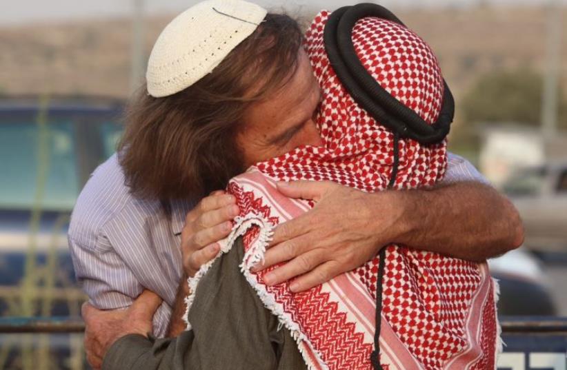 A rabbi and a sheikh embrace at a co-existence meeting (photo credit: MARC ISRAEL SELLEM)