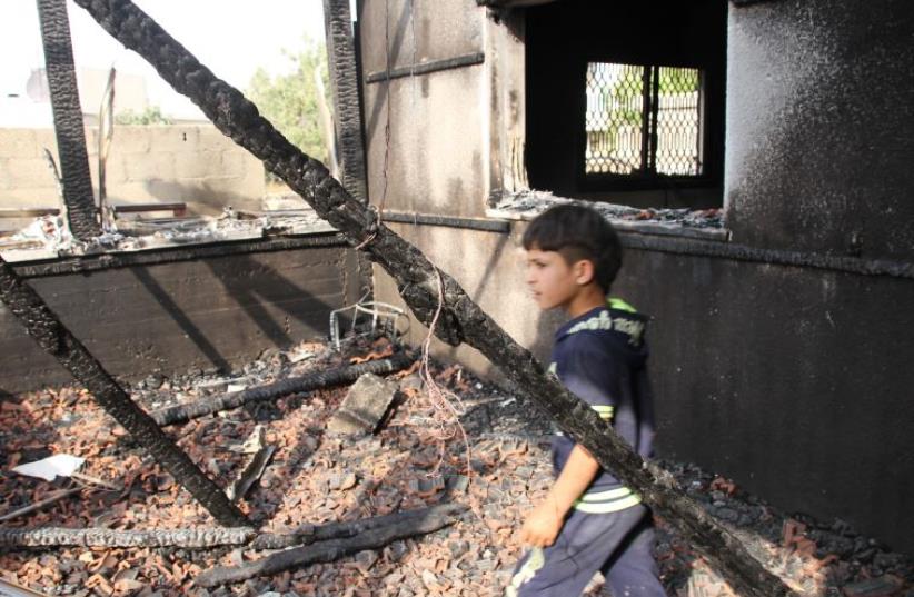 One of the boys from the family in Duma walks among the ruins (photo credit: TOVAH LAZAROFF)