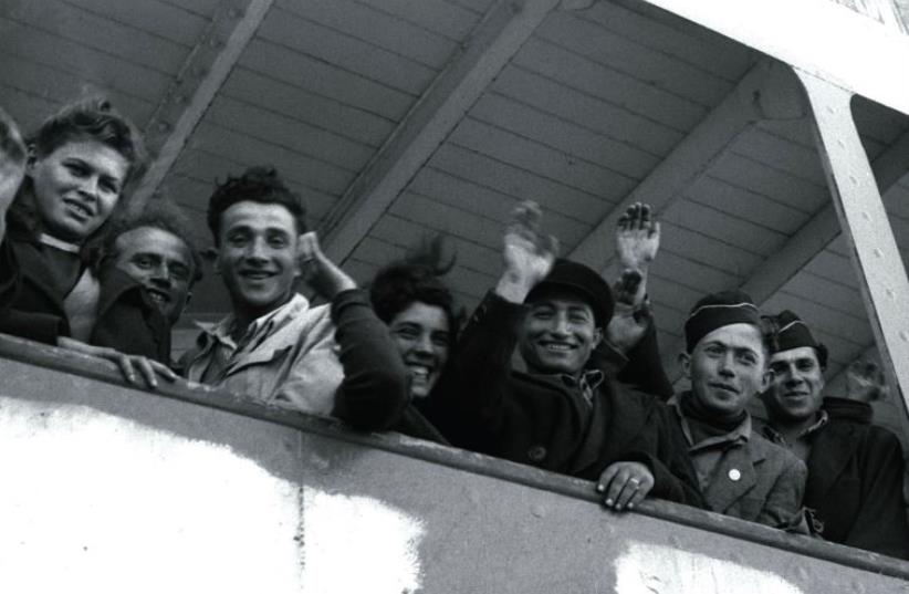 NEWLY ARRIVING Jewish refugees from Europe wave from the ship ‘S.S. Awarea’ as it pulls into Haifa port in 1948 (photo credit: REUTERS)