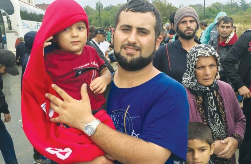 A family from Aleppo waits to cross into Macedonia. Thousands of migrants take this route towards Hungary and into the EU (photo credit: SETH J. FRANTZMAN)