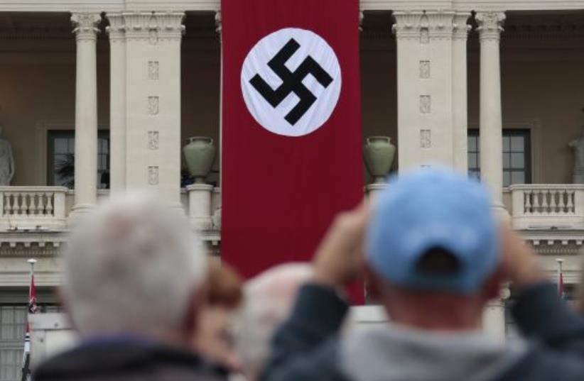 A Nazi swastika banner hangs on the facade of the Prefecture Palace in Nice which is being used as part of a movie set during the filming of a WWII film in the old city of Nice, France (photo credit: REUTERS)