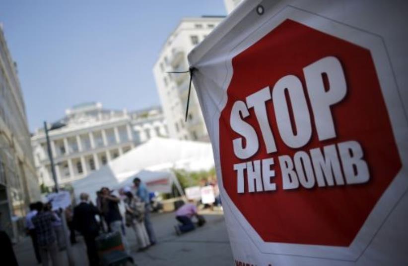 A sign which reads "Stop the Bomb" is seen as protesters gather outside the hotel where the Iran nuclear talks were being held in Vienna (photo credit: REUTERS)