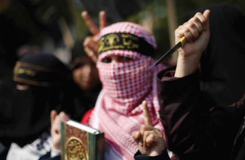 A PALESTINIAN woman holds up a knife in the Gaza Strip. (photo credit: REUTERS)