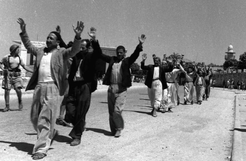 ARAB RESIDENTS of the town of Ramle, southeast of Tel Aviv, raise their hands in surrender to Israeli soldiers in July of 1948. Did the Mufti represent them? (photo credit: REUTERS)