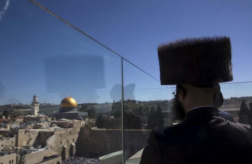 An ultra-Orthodox Jewish man stands on the rooftop during a special priestly blessing for Passover at the Western Wall (photo credit: REUTERS)