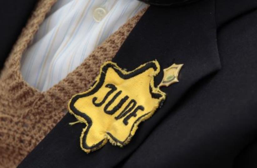 A Holocaust survivor wears a yellow star during a ceremony at the Yad Vashem Holocaust Memorial in Jerusalem (photo credit: REUTERS)