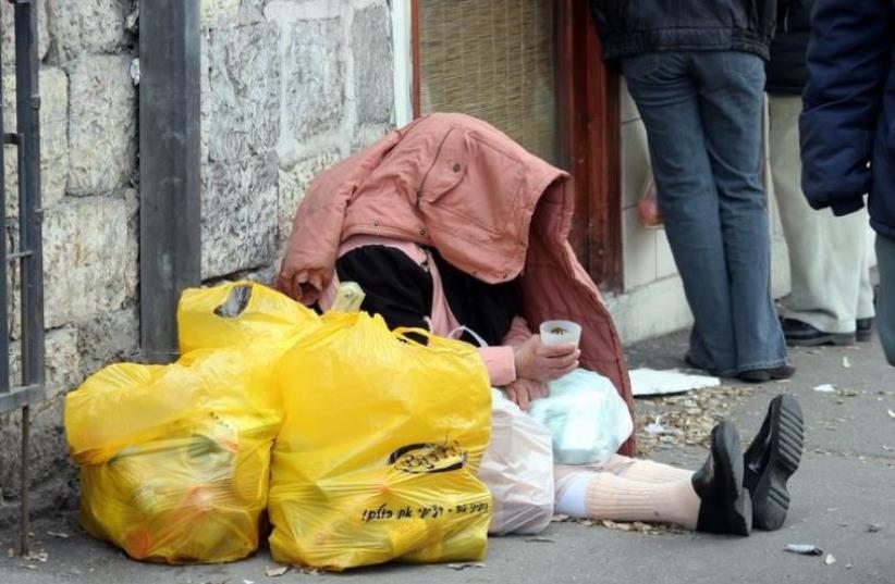 A homeless person begs for change in Israel (photo credit: MARC ISRAEL SELLEM/THE JERUSALEM POST)