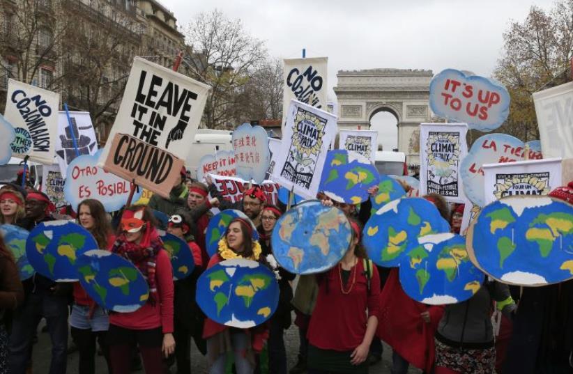 Environmentalists demonstrate near the Arc de Triomphe in Paris, France, as the World Climate Change Conference 2015 (COP21) meets, December 12, 2015 (photo credit: REUTERS)