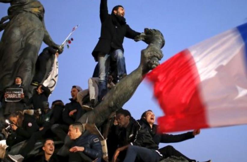 A man holds a giant pencil as he takes part in a solidarity march in the streets of Paris after the Charlie Hebdo shootings (photo credit: REUTERS)