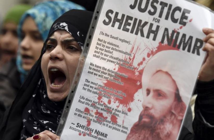 A protester holds a placard during a demonstration against the execution of Shi'ite cleric Sheikh Nimr al-Nimr in Saudi Arabia, outside the Saudi Arabian Embassy in London, Britain, January 3, 2016 (photo credit: REUTERS/TOBY MELVILLE)