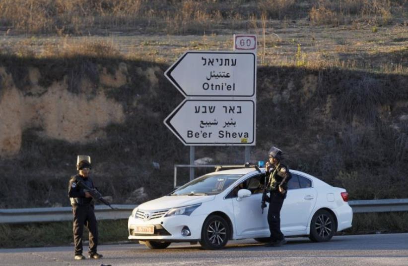 Israeli policemen stand near a checkpoint close to the West Bank settlement of Otniel (photo credit: REUTERS)