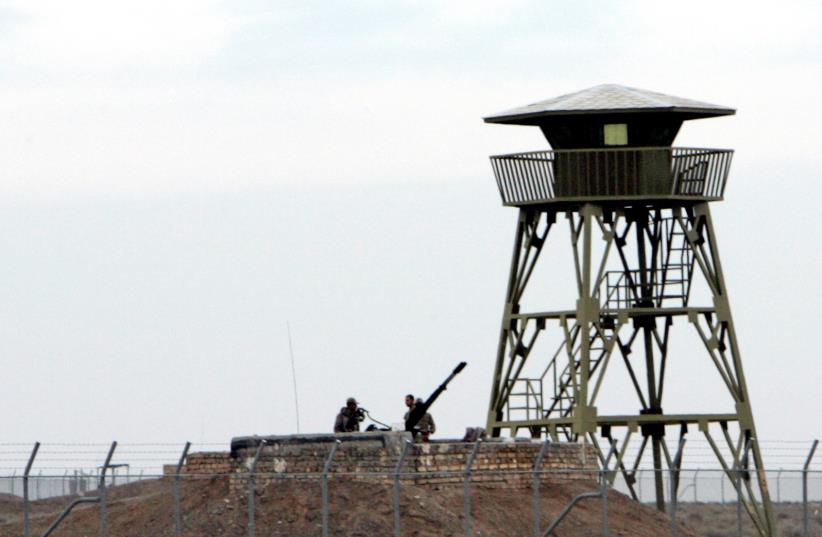 ranian soldiers stand guard on an anti-aircraft machine gun inside the Natanz uranium enrichment facility, 322km (200 miles) south of Iran's capital Tehran March 9, 2006.  (photo credit: REUTERS)