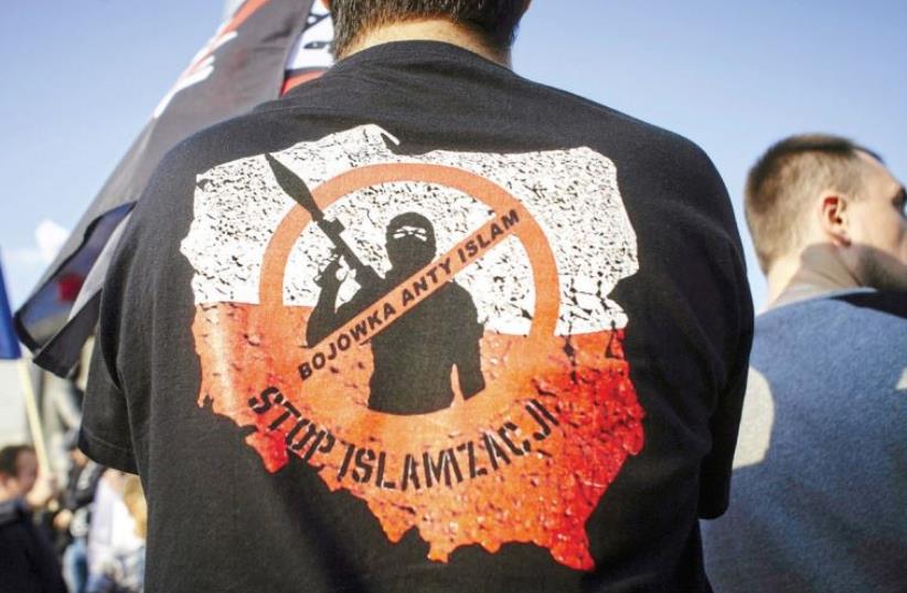 ACTIVISTS PROTEST against refugees in Lodz, Poland in September 2015. The words on the shirt read, ‘Anti-Islam militia. Stop Islamization.’ (photo credit: REUTERS)