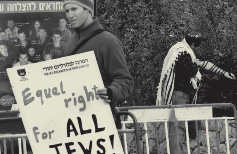 Protester holds a poster demanding equal rights for all Jews (photo credit: REUTERS)