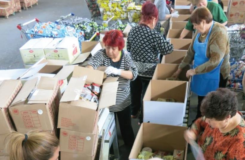 VOLUNTEERS PREPARE food packages for the needy ahead of Passover at a Kolel Chabad center earlier this week (photo credit: KOLEL CHABAD)