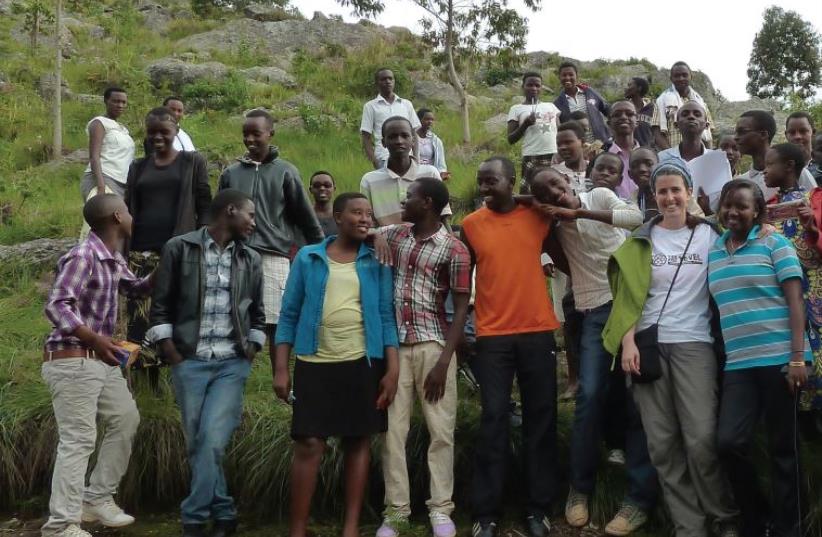 Gal Vinikov poses with a group of village kids in Vuzigo (photo credit: COURTESY TEVEL B’TZEDEK)