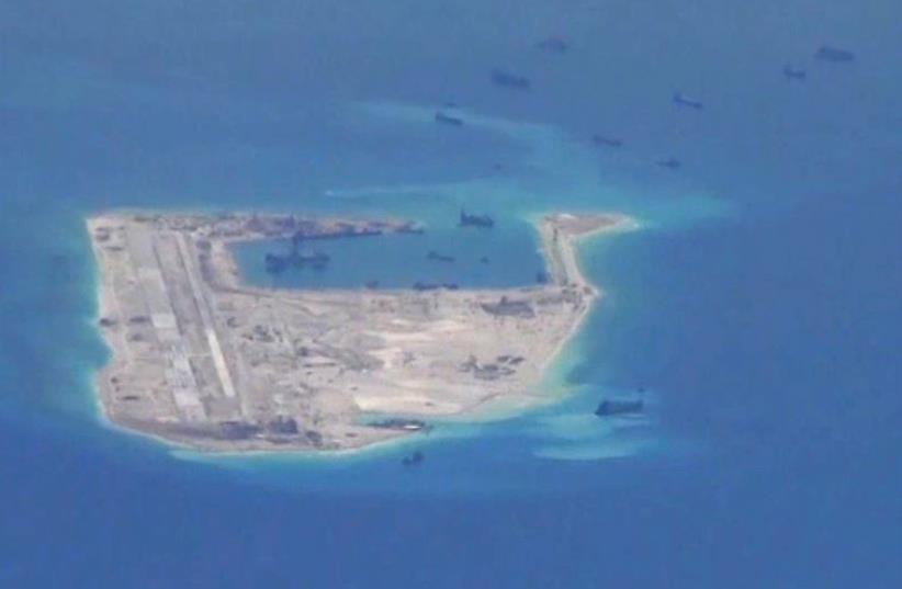 Chinese dredging vessels are purportedly seen in the waters around Fiery Cross Reef in the disputed Spratly Islands in the South China Sea in this still image from video taken by a P-8A Poseidon surveillance aircraft provided by the United States Navy May 21, 2015.  (photo credit: US NAVY/HANDOUT VIA REUTERS)