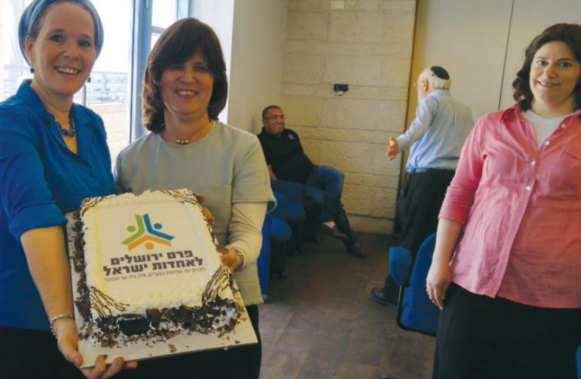 Rachelle Sprecher Fraenkel (left) and Tzila Schneider hold a cake celebrating the Jewish Unity Prize (photo credit: Courtesy)