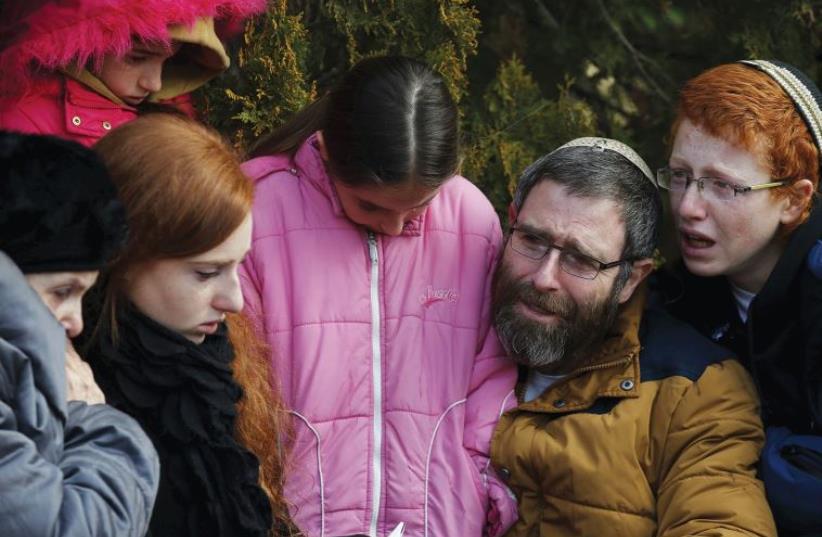 THE FAMILY of the late Dafna Meir mourn during her funeral ceremony in January. (photo credit: REUTERS)