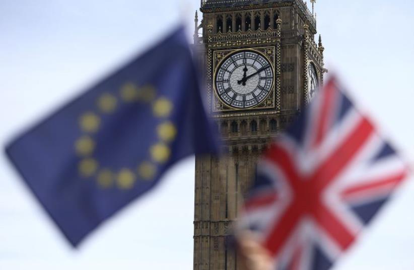 Participants hold a British Union flag and an EU flag during a pro-EU referendum event at Parliament Square in London, Britain June 19, 2016. (photo credit: REUTERS)