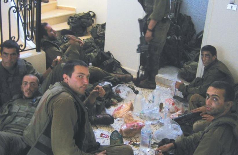 BENYAMIN BEN-ARI (third from left, foreground) and his buddies eat lunch in south Lebanon 10 years ago. (photo credit: COURTESY BENYAMIN BEN-ARI)