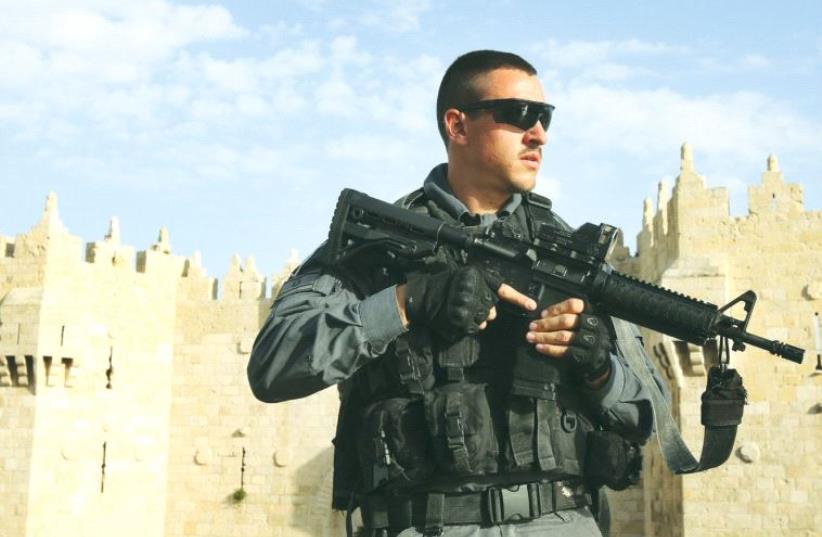 A BORDER POLICE officer patrols the area outside the Damascus Gate of Jerusalem’s Old City recently. (photo credit: MARC ISRAEL SELLEM)