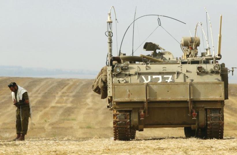 A soldier prays near the border with the Gaza Strip in July 2014 (photo credit: MARC ISRAEL SELLEM)