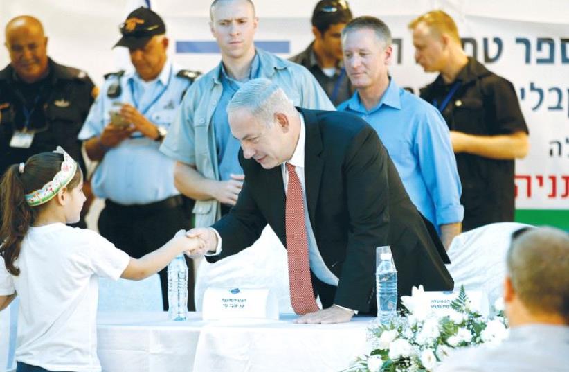 PRIME MINISTER Benjamin Netanyahu greets a pupil during a visit at the Tamra Ha’emek elementary school on the first day of the school year, in the Arab town of Tamra in the Lower Galilee. (photo credit: BAZ RATNER)