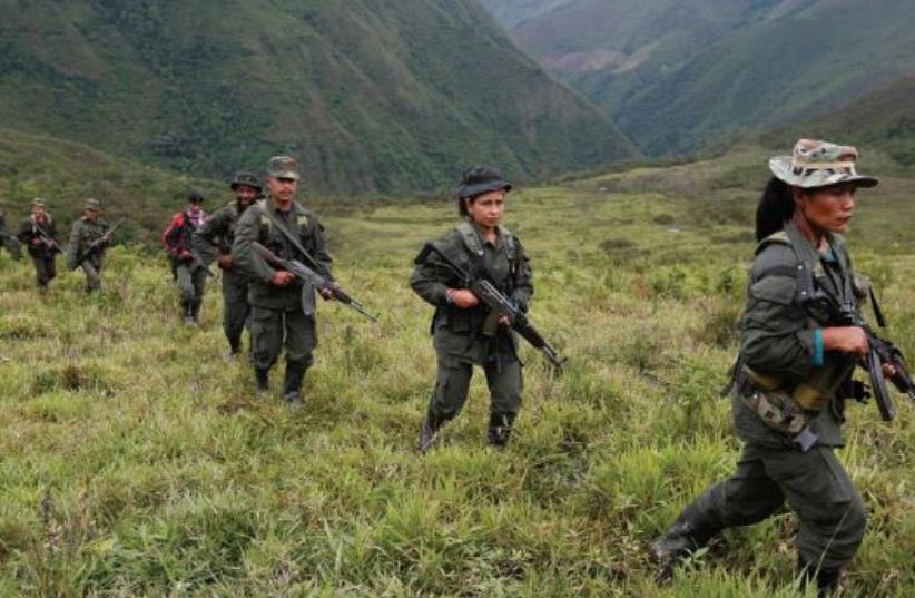 WILL ALL this be over now? Members of the 51st Front of the Revolutionary Armed Forces of Colombia (FARC) patrol in the remote mountains of Colombia, last month (photo credit: REUTERS)