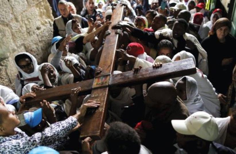 ETHIOPIAN CHRISTIAN worshipers carry a cross during a procession along Via Dolorosa (photo credit: REUTERS)