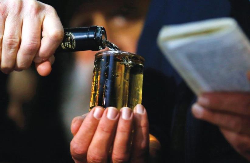 A CELEBRATORY GLASS OF WINE is poured before traditional blessings during an Orthodox wedding ceremony in Budapest, Hungary, in 2014. (photo credit: REUTERS)