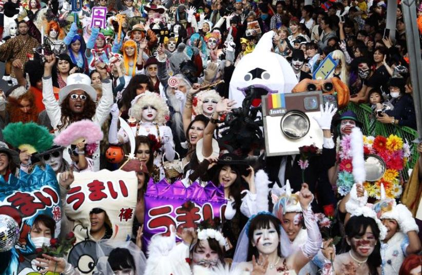 Participants wearing costumes take part in a Halloween parade in Kawasaki, south of Tokyo [File] (photo credit: REUTERS)