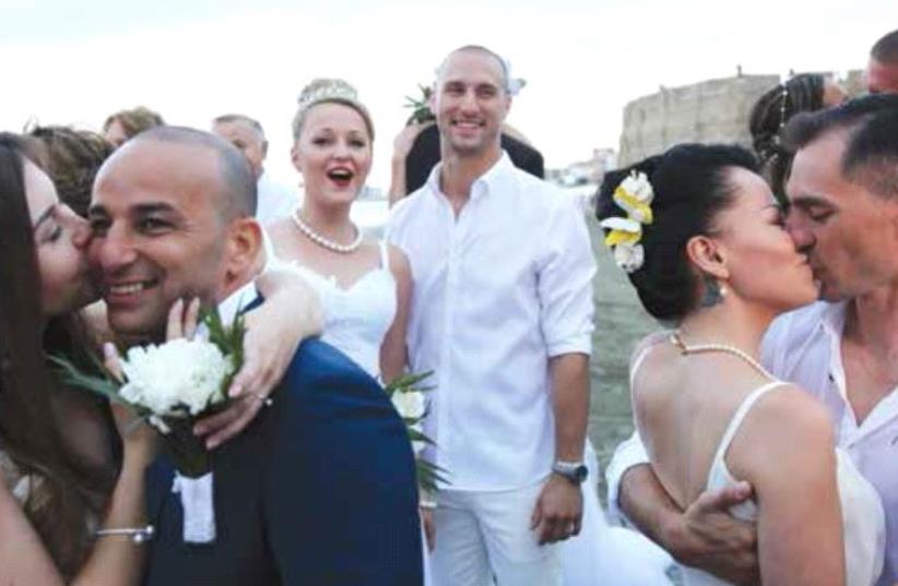 Couples of Russian and Israeli origins kiss during a mass wedding in Larnaca, Cyprus, in June last year (photo credit: REUTERS)