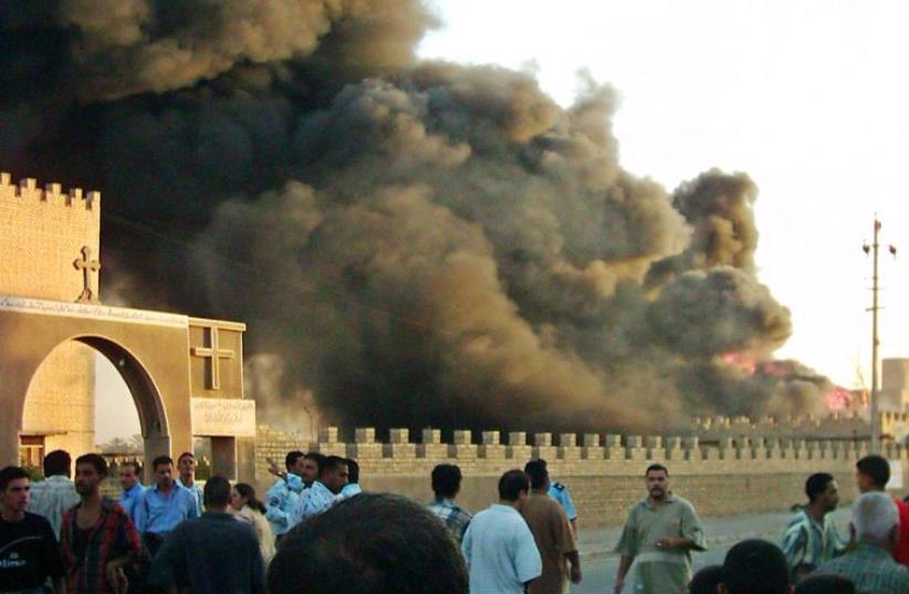 Iraqis crowd the area after an explosion in the car park outside an ancient Chaldean monastery in the Baghdad suburb of Al Doura. (photo credit: REUTERS)