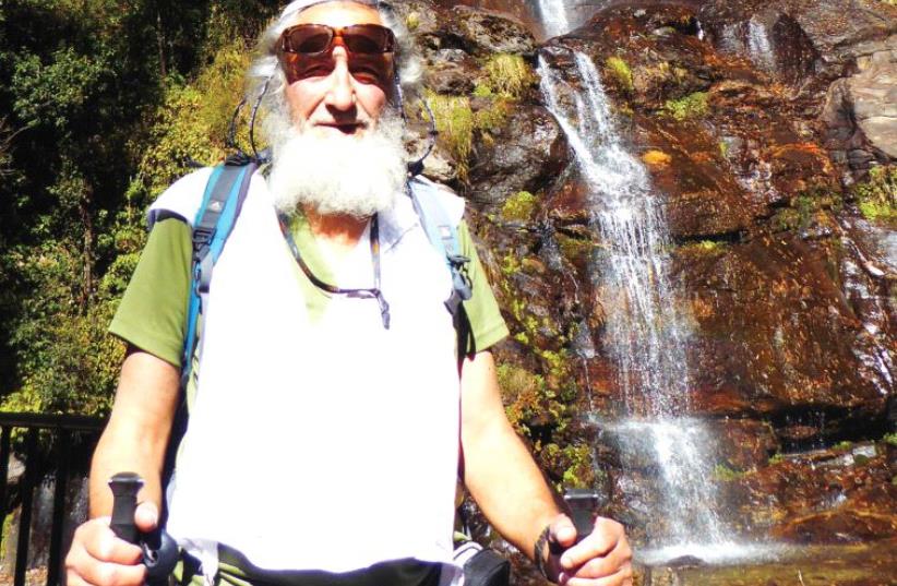 The writer pauses by a waterfall (photo credit: MICHEL KOGINSKY)