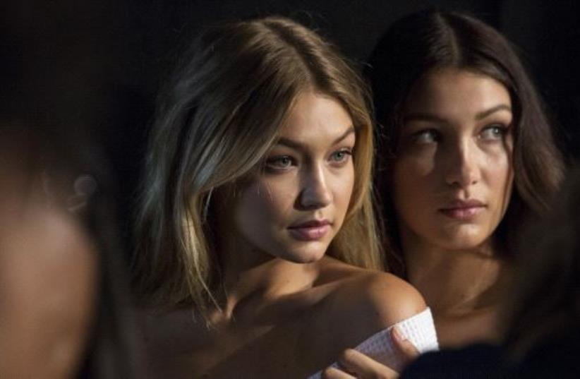 Models Gigi Hadid (L) and Bella Hadid pose for photos (photo credit: REUTERS)