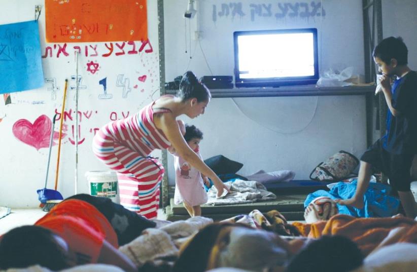 A MOTHER puts her children to bed in a public bomb shelter in Ashkelon during the 2014 Gazan war (photo credit: REUTERS)