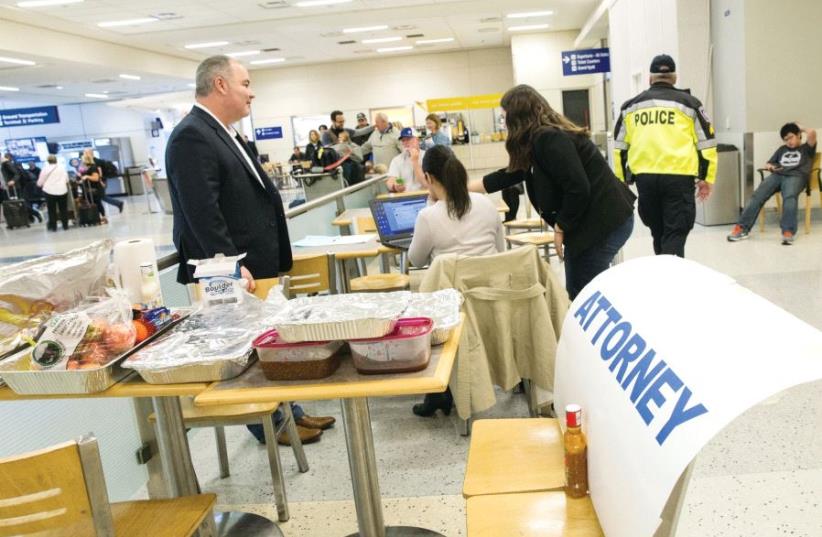 Attorneys volunteer their services at Dallas/Fort Worth International Airport, Texas, earlier this month (photo credit: REUTERS)