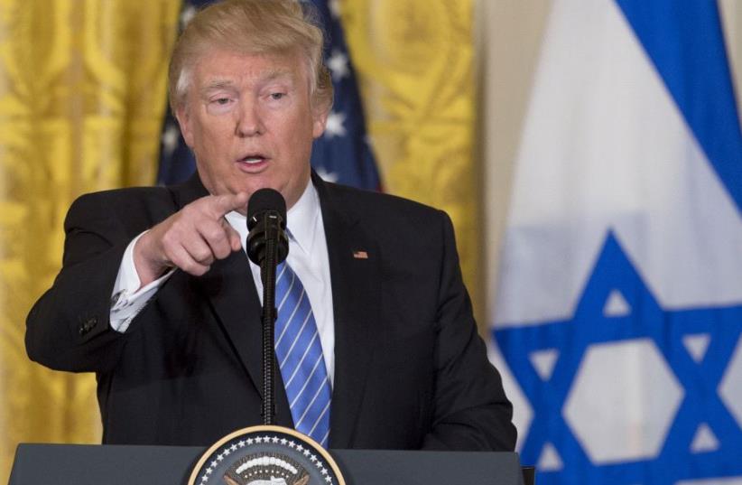 Donald Trump speaks during a joint press conference with Minister Benjamin Netanyahu in the East Room of the White House in Washington , DC on Feb. 15, 2017 with an Israeli flag in the background (photo credit: SAUL LOEB / AFP)