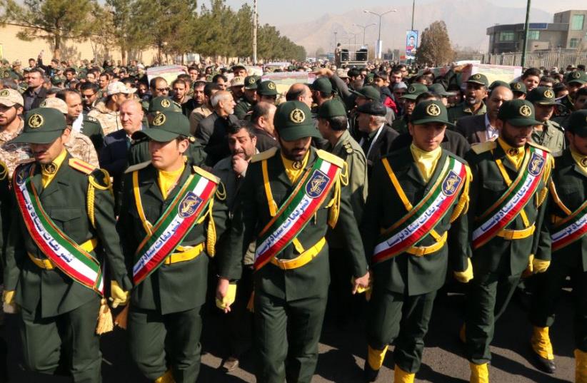 Iranian Revolutionary Guard members in Tehran carry the casket of Iran Revolutionary Guards Brigadier General Mohsen Ghajarian, who was killed in the northern province of Aleppo , Syria  (photo credit: ATTA KENARE / AFP)