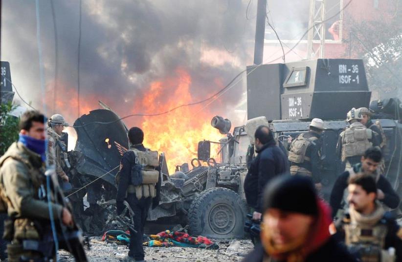 Iraqi Special Operations Forces (ISOF) are seen after a car bomb explodes during an operation to clear the al-Andalus district of Mosul of Islamic State militants, January 17 (photo credit: REUTERS)