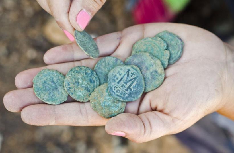 Rare 1,400-year-old bronze Byzantine-era coins found near Jerusalem’s Highway 1 (photo credit: YOLI SCHWARTZ/IAA)