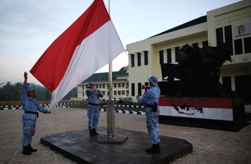 PARTICIPANTS RAISE an Indonesian flag at a training center in Rumpin, Indonesia, last June. (photo credit: REUTERS)