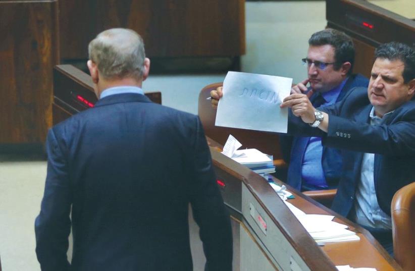 JOINT LIST chairman Ayman Odeh holds a piece of paper with the word ‘corrupt’ on it toward Prime Minister Benjamin Netanyahu in the Knesset (photo credit: MARC ISRAEL SELLEM/THE JERUSALEM POST)