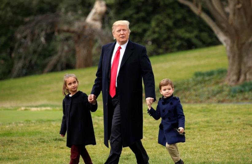 U.S. President Donald Trump holds hands with grandchildren Arabella and Joseph Kushner (photo credit: KEVIN LAMARQUE/REUTERS)