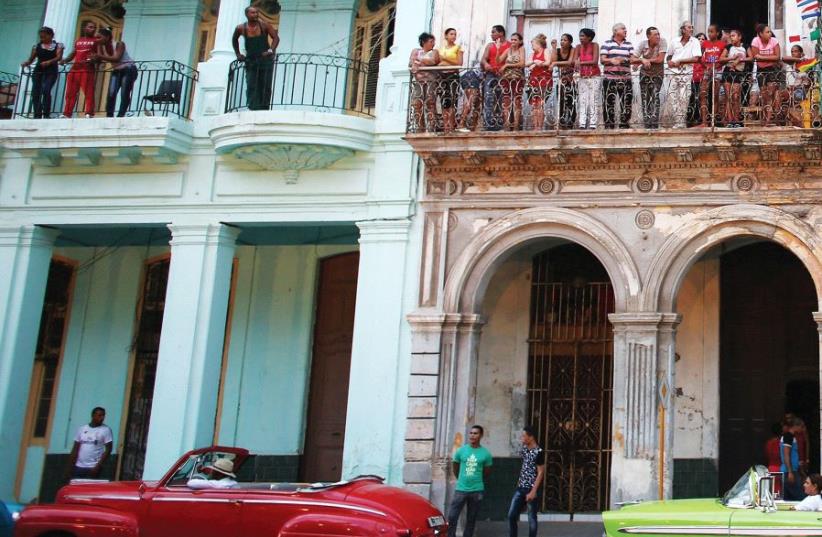 PEOPLE STAND on balconies on Paseo del Prado street in Havana, Cuba. (photo credit: REUTERS)