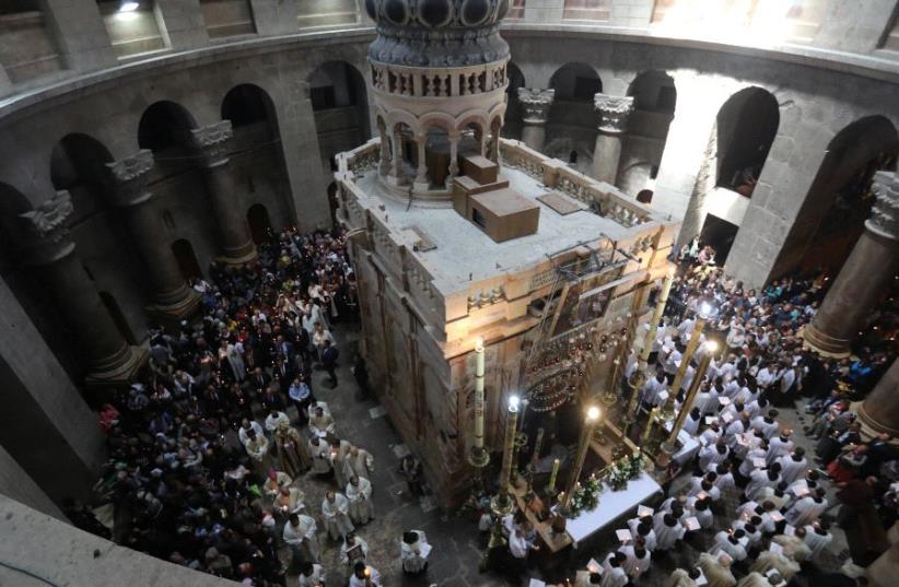 Christian worshippers in Israel surround the Edicule as they take part in a Sunday Easter mass procession in the Church of the Holy Sepulchre in Jerusalem's Old City (photo credit: REUTERS)